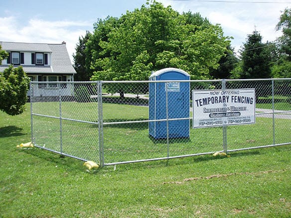 porta potty in a backyard with a fence