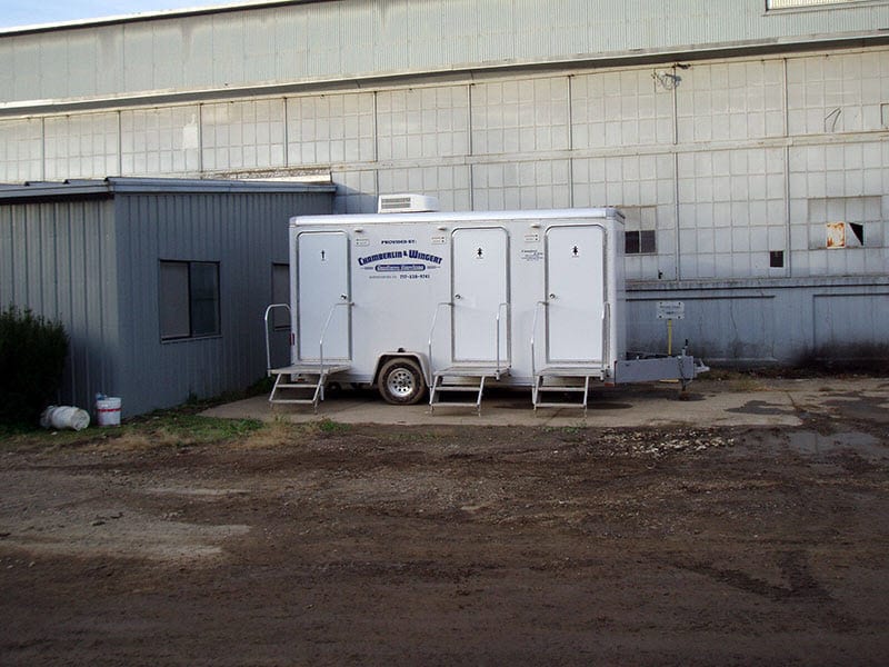 portable restroom trailer by a warehouse