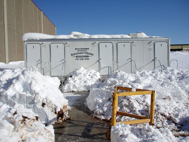 luxury restroom trailer surrounded by snow piles